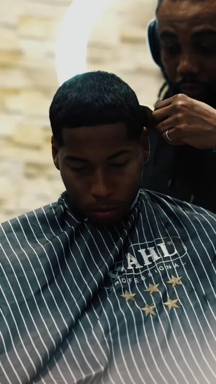 Barber en train de finir une coupe courte, 235th Barber Street Ivry